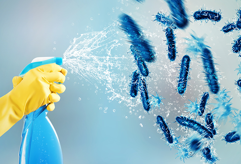 Professional cleaner wiping down a modern office conference table with blue gloves and microfiber cloth